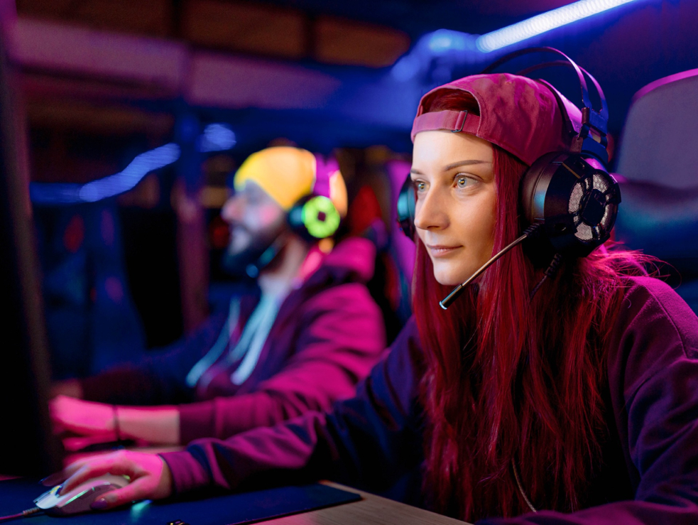 Zwei Jugendliche vor dem Computer mit Headset.